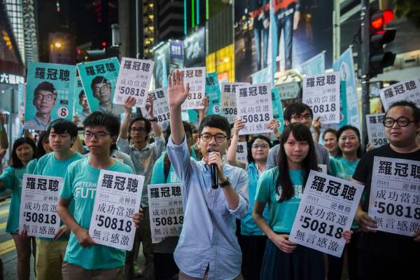 Nathan Law (C) speaks at a rally with Jousha Wong (centre L) and supporters in Causeway bay following Nathan Laws win in the Legislative Council election in Hong Kong on September 5, 2016. A new generation of young Hong Kong politicians advocating a break from Beijing looked set to become lawmakers for the first time on September 5 in the biggest poll since mass pro-democracy rallies in 2014. / AFP / ISAAC LAWRENCE        (Photo credit should read ISAAC LAWRENCE/AFP/Getty Images)
